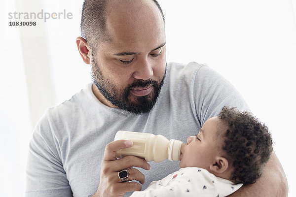 Vater füttert seinen Sohn mit der Flasche