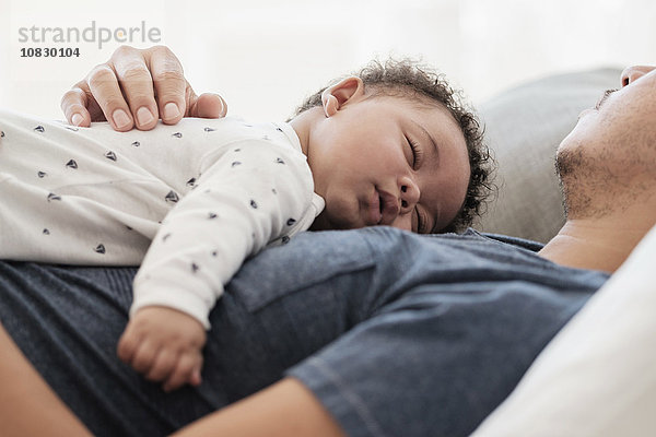 Vater und kleiner Sohn schlafen auf dem Bett