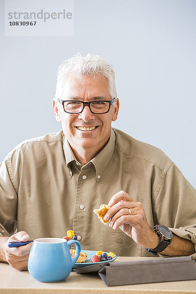 Kaukasischer Mann beim Essen am Tisch