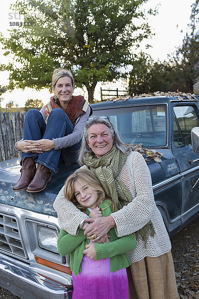 Drei Generationen kaukasischer Frauen sitzen auf einem Lastwagen