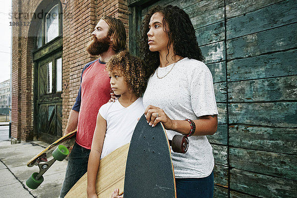 Familie hält Skateboards im Freien