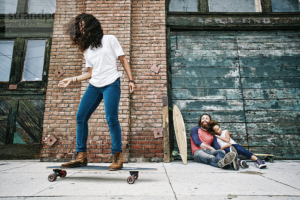 Familie fährt Skateboard auf dem Bürgersteig