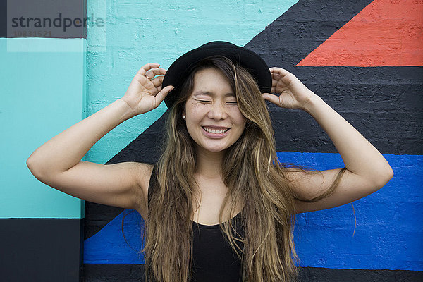 Asiatische Frau lächelnd mit geschlossenen Augen