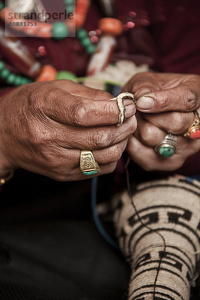 Nahaufnahme eines Künstlers  der traditionellen Schmuck herstellt