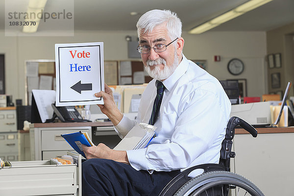 Kaukasischer Geschäftsmann hält Wahlplakat im Büro