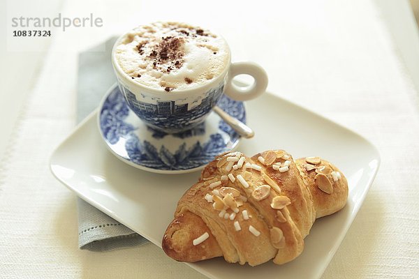 Cappuccino und Mandel-Croissant