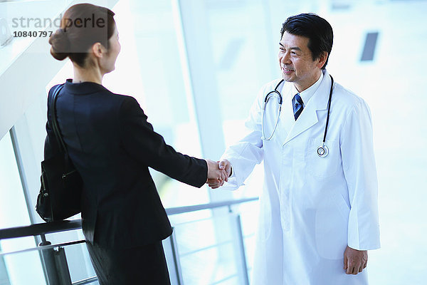 Japanischer Oberarzt mit Geschäftsfrau im Krankenhaus