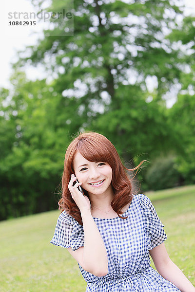 Junge attraktive japanische Frau in einem Stadtpark