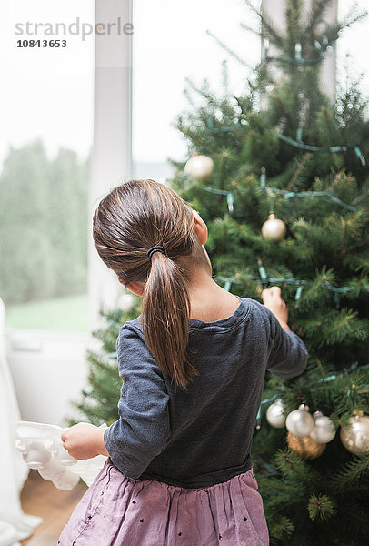 Kleinkind Mädchen schmückt Weihnachtsbaum