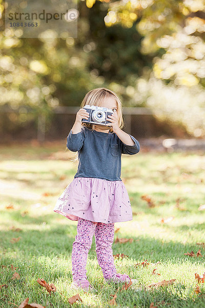 Kleinkind Mädchen mit Retro-Kamera im Herbstpark