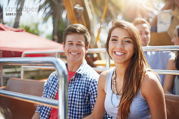 Portrait lächelndes junges Paar auf einer Fahrt im Vergnügungspark