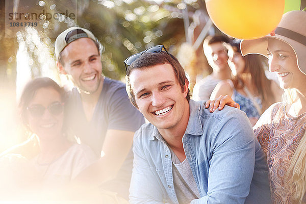 Portrait lächelnder junger Mann mit Freunden Sommer im Freien