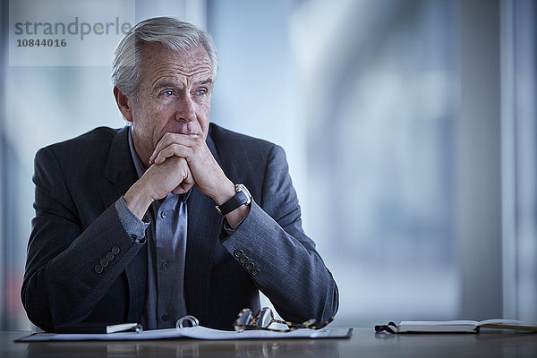 Nachdenklicher Geschäftsmann mit Blick in den Konferenzraum