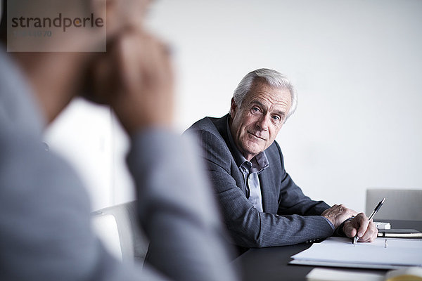 Senior Geschäftsmann beim Zuhören im Meeting