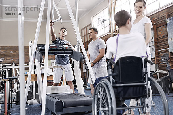 Physiotherapeuten bereiten Laufband für Menschen im Rollstuhl vor