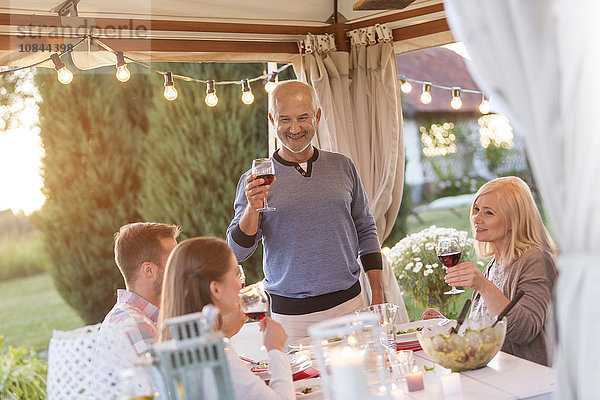 Senior Mann Toast Familie mit Rotwein auf der Terrasse Tisch