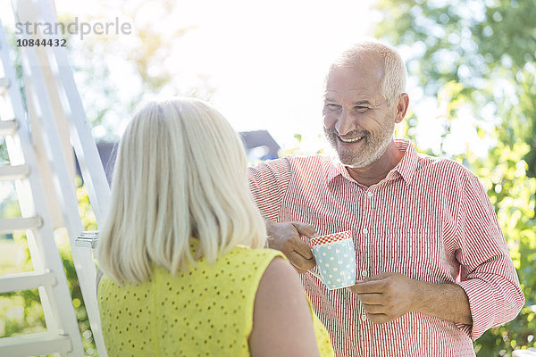 Lächelndes Seniorenpaar beim Kaffeetrinken im Freien