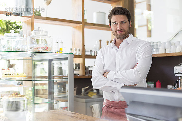 Portrait lächelnder Kellner hinter der Theke im Cafe