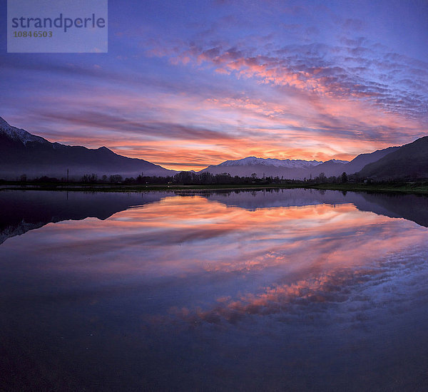 Panoramablick auf Pian di Spagna mit schneebedeckten Gipfeln  die sich bei Sonnenuntergang im Wasser spiegeln  Valtellina  Lombardei  Italien  Europa