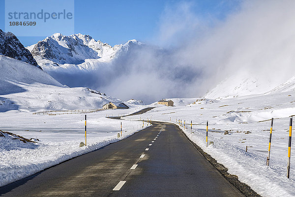 Die Strasse führt durch das schneebedeckte Tal  Albulapass  Engadin  Graubünden  Schweiz  Europa