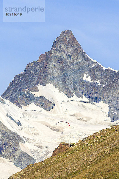 Ein Gleitschirmflieger fliegt vor dem majestätischen Obergabelhorn  Kanton Wallis  Penninische Alpen  Schweizer Alpen  Schweiz  Europa