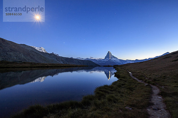 Vollmond und Matterhorn beleuchtet zum 150. Jahrestag der Erstbesteigung  gespiegelt im Stellisee  Zermatt  Kanton Wallis  Schweizer Alpen  Schweiz  Europa