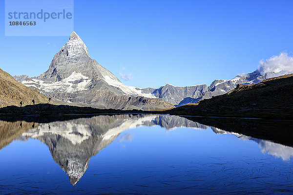 Wanderer bewundern das Matterhorn  das sich im Stellisee spiegelt  Zermatt  Kanton Wallis  Penninische Alpen  Schweizer Alpen  Schweiz  Europa