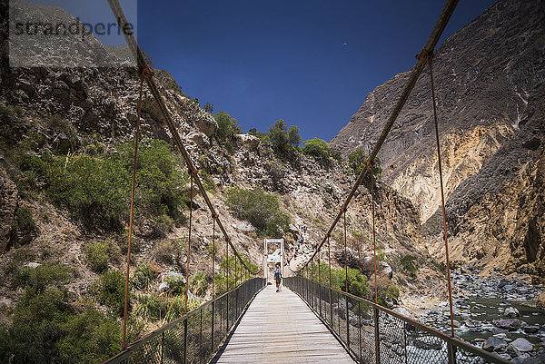 Menschen beim Trekking über die Colca River Bridge  Colca Canyon  Peru  Südamerika