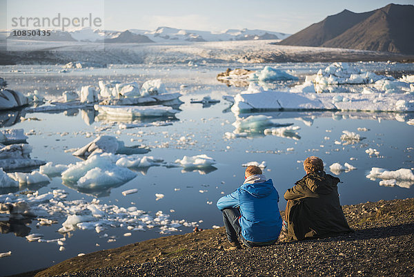 Vater und Sohn im Urlaub an der Gletscherlagune Jokulsarlon bei Sonnenuntergang  Südostisland  Island  Polarregionen