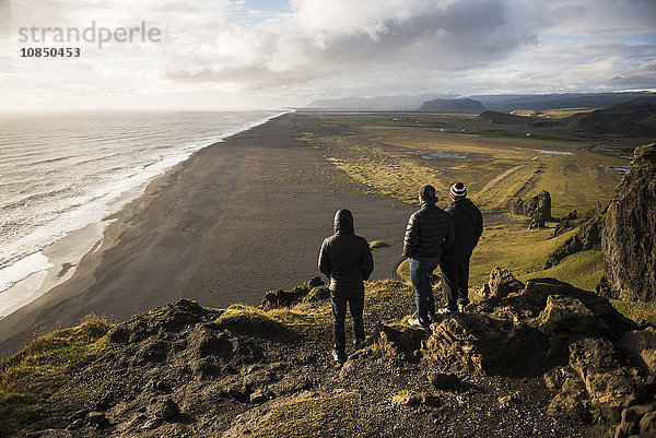 Touristen betrachten die Aussicht bei Sonnenuntergang von der Halbinsel Dyrholaey  in der Nähe von Vik  Südisland (Sudurland)  Island  Polarregionen