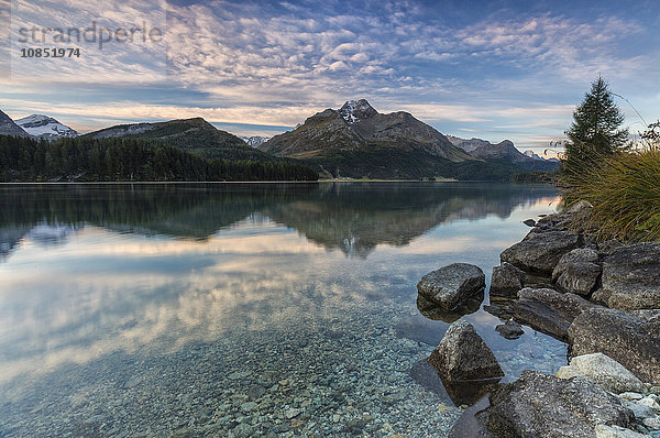 Rosa Himmel in der Morgendämmerung beleuchtet die Gipfel  die sich im Silsersee spiegeln  Engadin  Kanton Graubünden  Schweiz  Europa