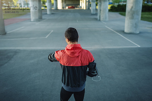 Rear view of man checking time while standing on street