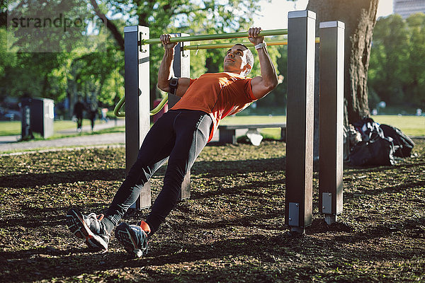 Man exercising on railing at park