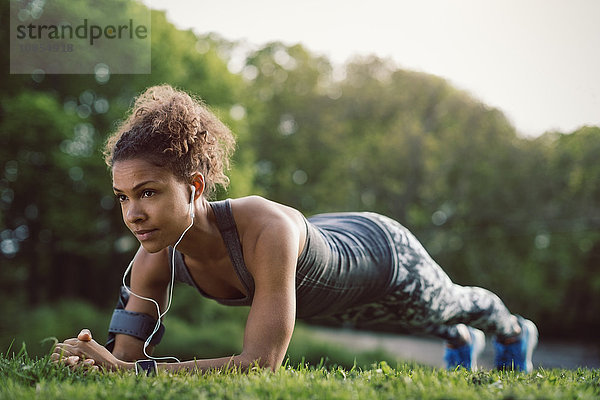 Sporty woman doing plank exercise at park