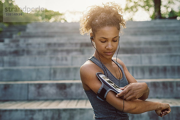 Woman using smart phone armband while exercising