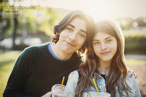 Portrait of smiling teenagers at park on sunny day