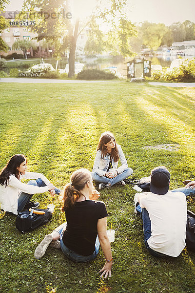 High angle view of teenagers relaxing on grass