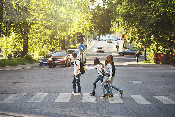 Side view of teenagers crossing road