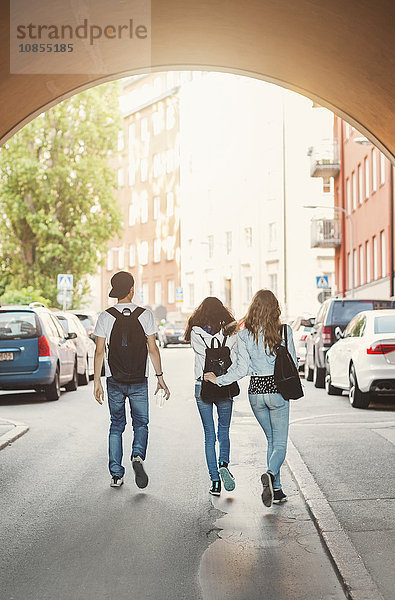 Rear view of teenagers walking in tunnel