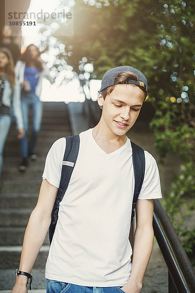 Teenager moving down steps with friends in background