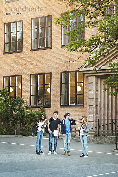 Friends talking while standing outside building