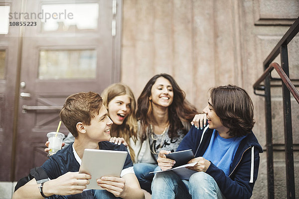 Happy teenagers enjoying on steps outdoors