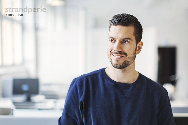 Confident businessman looking away in office