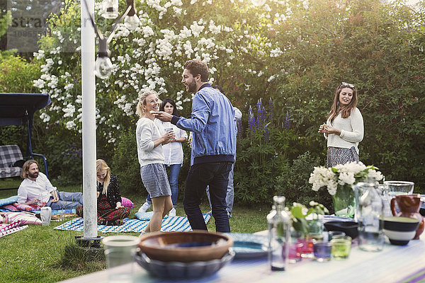 Happy multi-ethnic friends enjoying summer party in backyard