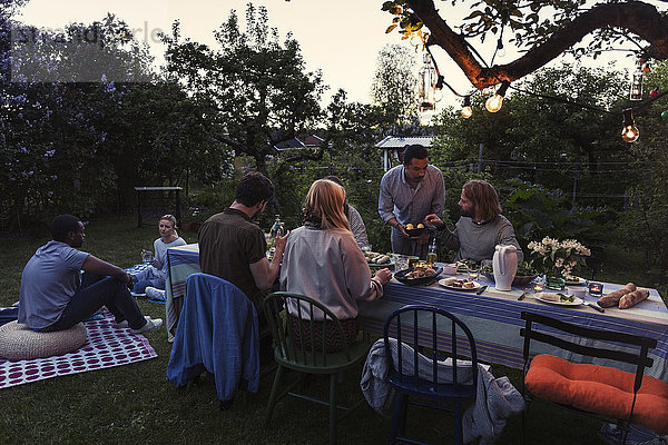 Friends having food during dinner party at yard