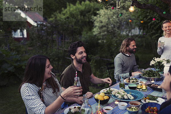 Happy friends enjoying dinner party at yard