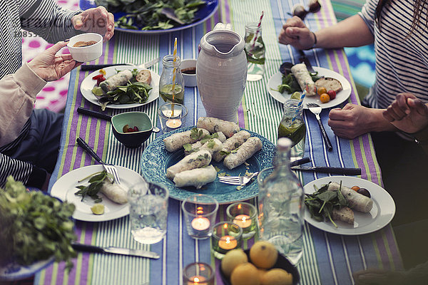 High angle view of friends sitting at dinner table in yard