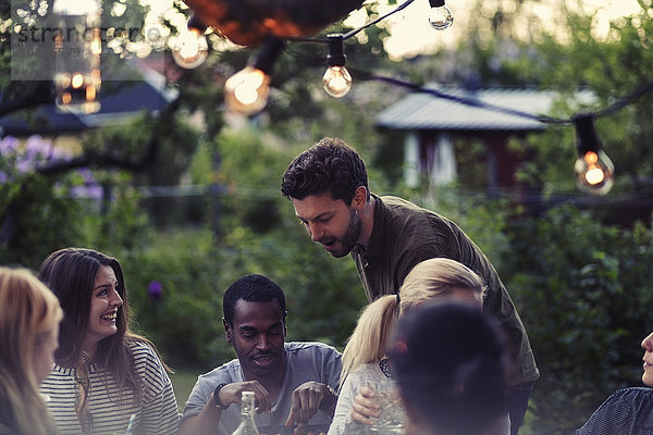 Man enjoying dinner party with friends at yard