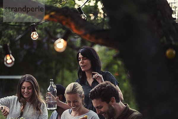 Happy friends enjoying dinner party at yard