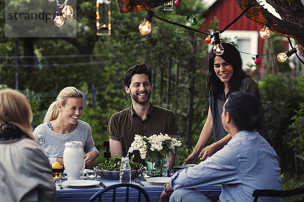 Happy friends enjoying dinner party at yard